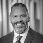 A black and white photo of a man in a suit.