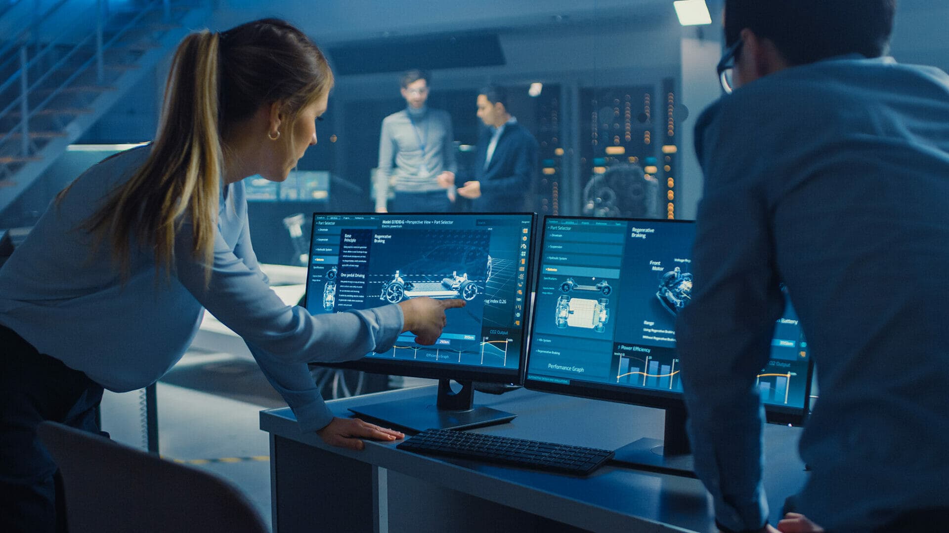 Two people looking at computer screens in an office.