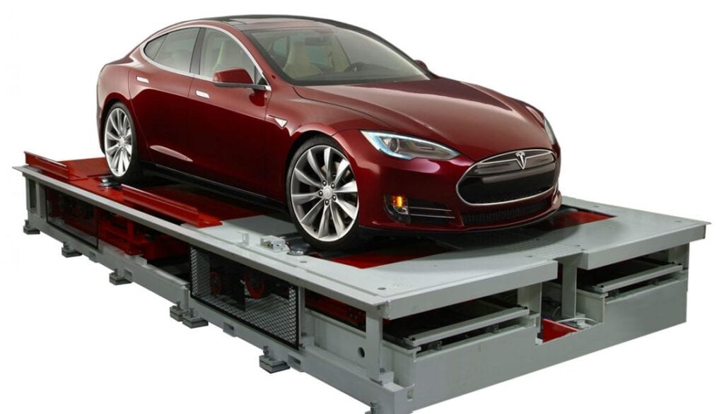 A red tesla model s sitting on a platform.