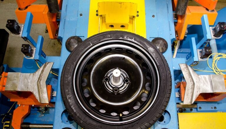 A tire on a blue and yellow machine.