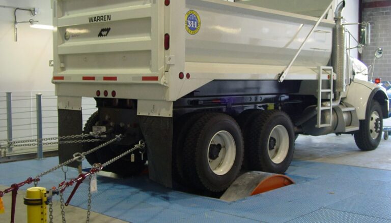 A white dump truck in a garage.