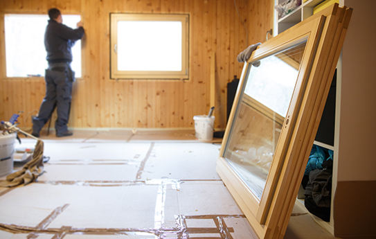 A man is standing in a room that is being remodeled.