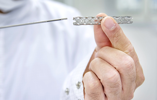 A man is holding a piece of metal in his hand.